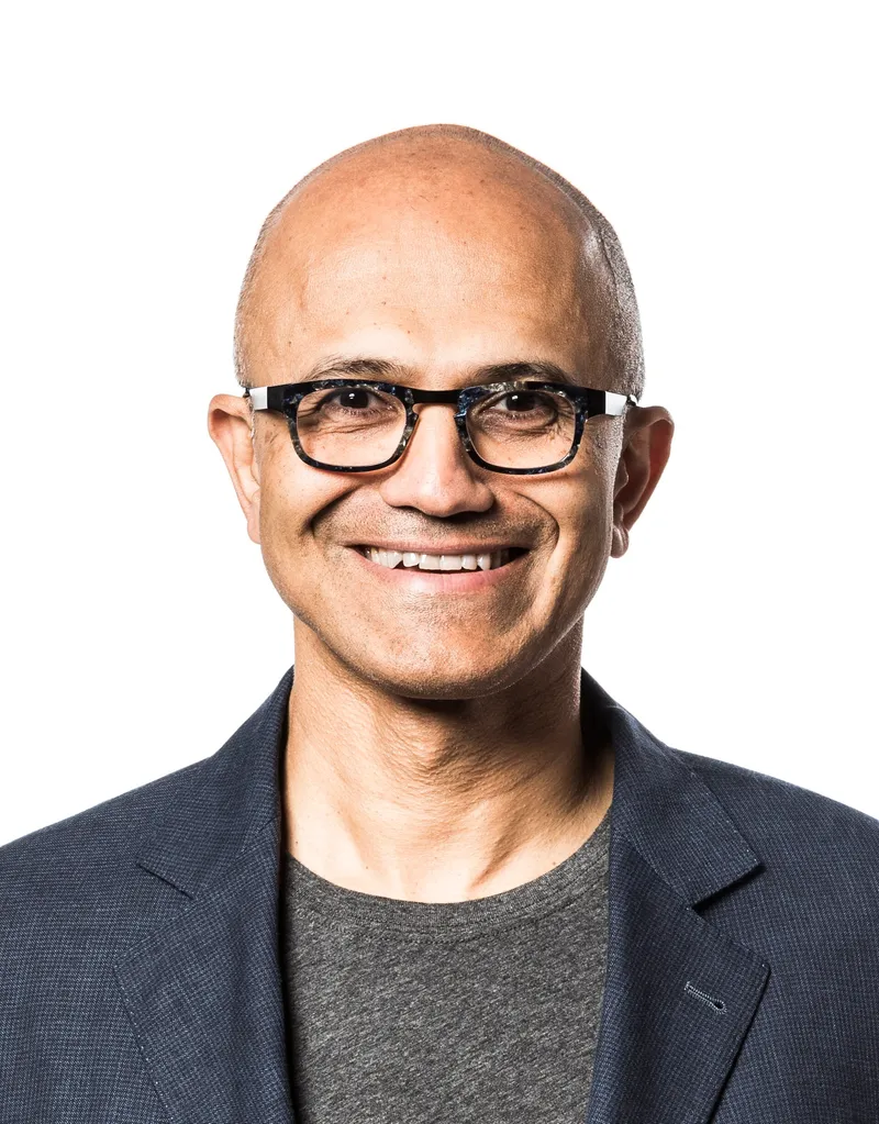 Satya Nadella, Microsoft chairman and CEO, in glasses and a dark jacket, photographed against a plain background.